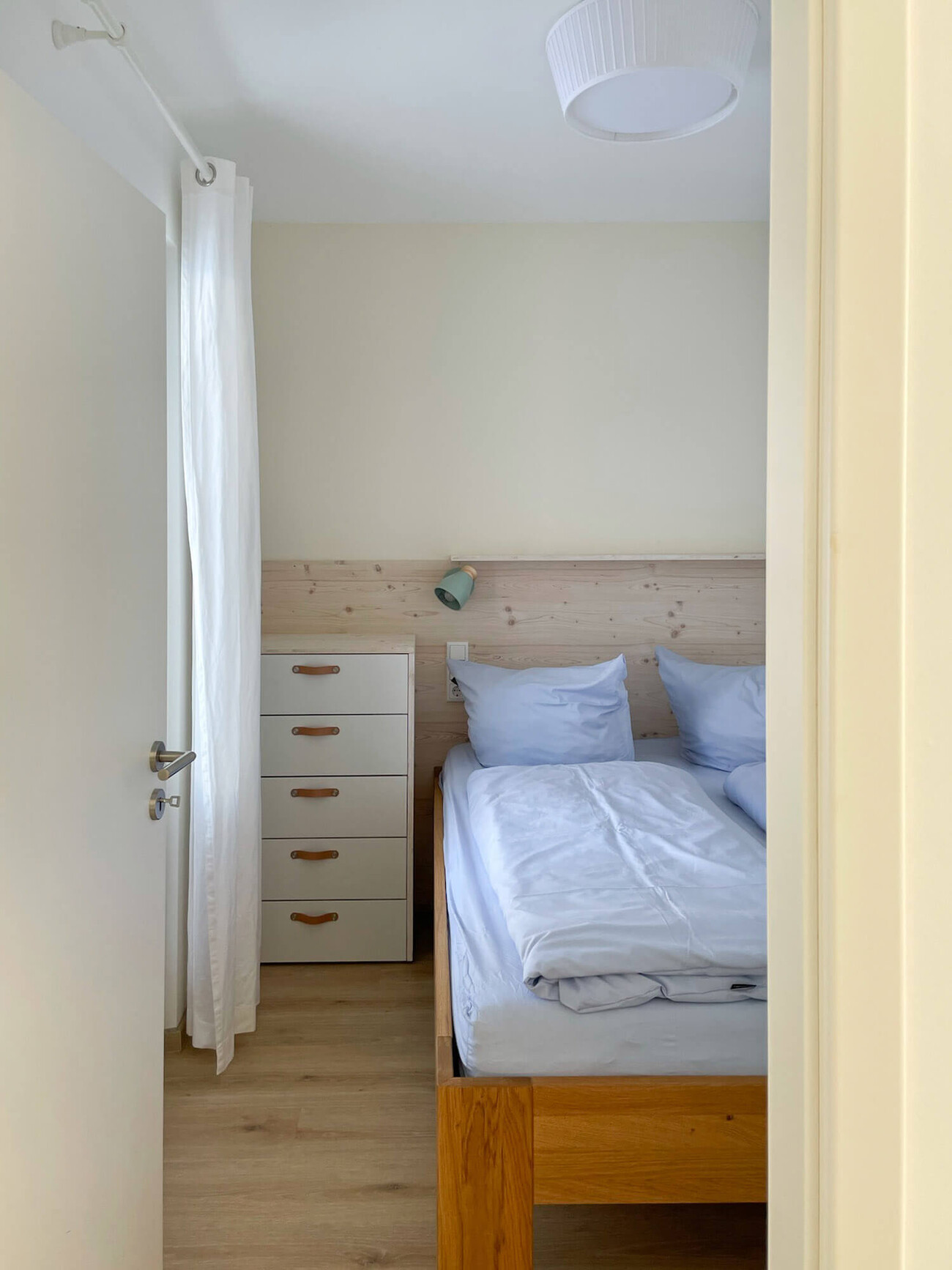 Wohnung 2: Gemütliches Schlafzimmer mit Bett und Kommode.