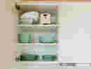 Geöffneter Küchen-Hängeschrank mit Tellern.