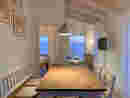 Wohnung 4: Blick in der Blauen Stunde vom Esstisch im Wohnzimmer auf den Hainer See. Links geht es zum Schlafzimmer, von dem man ebenfalls auf den See blicken kann.